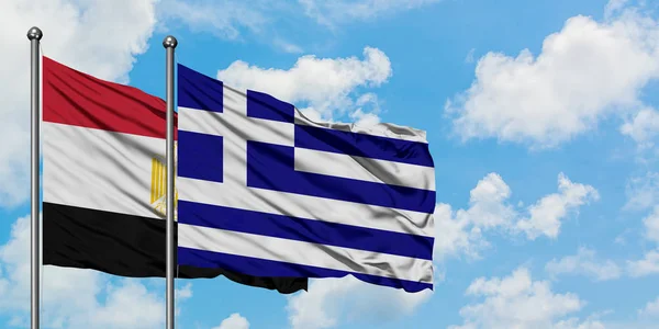 Bandera de Egipto y Grecia ondeando en el viento contra el cielo azul nublado blanco juntos. Concepto diplomático, relaciones internacionales . — Foto de Stock