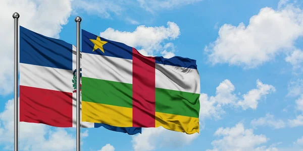 Bandera de República Dominicana y República Centroafricana ondeando en el viento contra el cielo azul nublado blanco juntos. Concepto diplomático, relaciones internacionales . — Foto de Stock