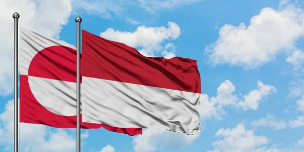 緑の国とインドネシアの旗は、一緒に白い曇り青い空に対して風に手を振る。外交概念、国際関係. — ストック写真