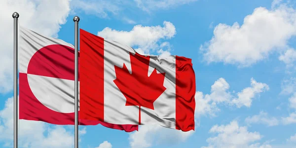 Bandera de Groenlandia y Canadá ondeando en el viento contra el cielo azul nublado blanco juntos. Concepto diplomático, relaciones internacionales . —  Fotos de Stock