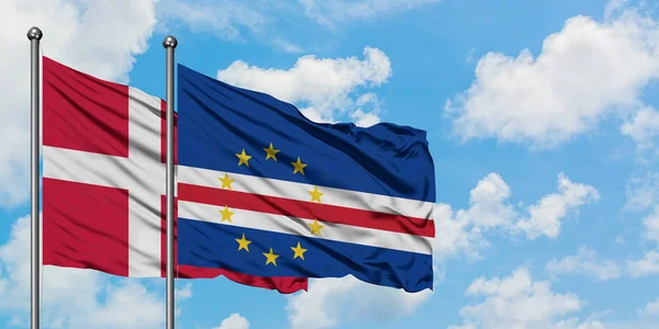 Bandera de Dinamarca y Cabo Verde ondeando en el viento contra el cielo azul nublado blanco juntos. Concepto diplomático, relaciones internacionales . — Foto de Stock