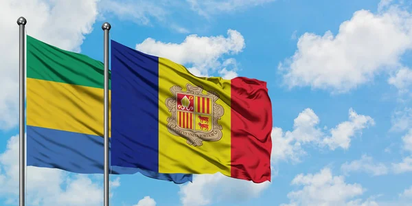 Gabon und andorra-flagge wehen gemeinsam im wind vor weißem wolkenblauem himmel. Diplomatie-Konzept, internationale Beziehungen. — Stockfoto