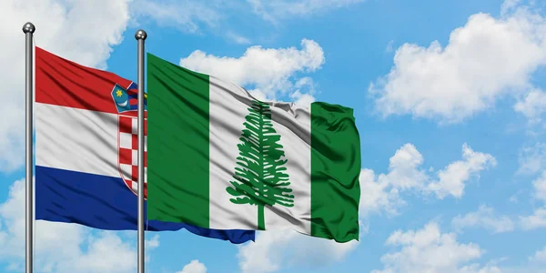 Bandera de Croacia y Norfolk Island ondeando en el viento contra el cielo azul nublado blanco juntos. Concepto diplomático, relaciones internacionales . — Foto de Stock