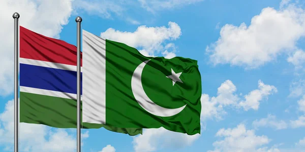 Bandera de Gambia y Pakistán ondeando en el viento contra el cielo azul nublado blanco juntos. Concepto diplomático, relaciones internacionales . — Foto de Stock