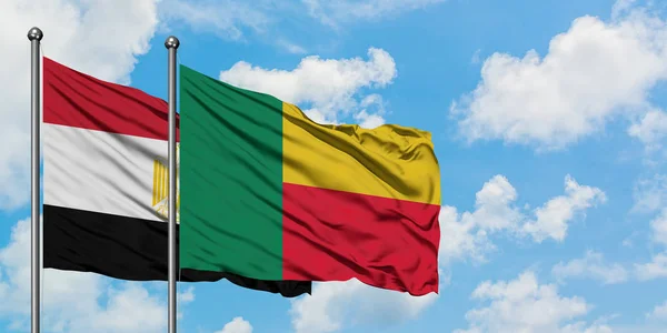 Bandera de Egipto y Benín ondeando en el viento contra el cielo azul nublado blanco juntos. Concepto diplomático, relaciones internacionales . — Foto de Stock
