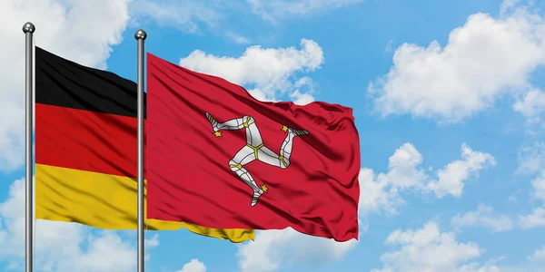 Almanya ve Isle Of Man bayrağı birlikte beyaz bulutlu mavi gökyüzüne karşı rüzgarda sallayarak. Diplomasi kavramı, uluslararası ilişkiler. — Stok fotoğraf