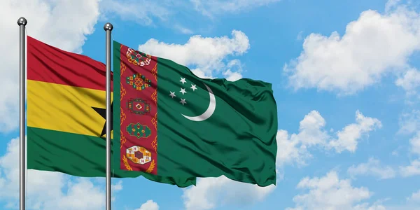 Bandera de Ghana y Turkmenistán ondeando en el viento contra el cielo azul nublado blanco juntos. Concepto diplomático, relaciones internacionales . — Foto de Stock