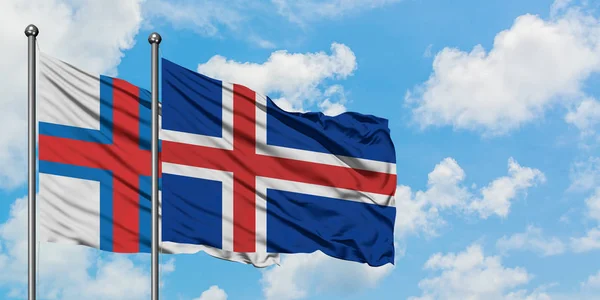 Bandera de las Islas Feroe e Islandia ondeando en el viento contra el cielo azul nublado blanco juntos. Concepto diplomático, relaciones internacionales . —  Fotos de Stock