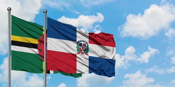 Bandera de Dominica y República Dominicana ondeando en el viento contra el cielo azul nublado blanco juntos. Concepto diplomático, relaciones internacionales . — Foto de Stock