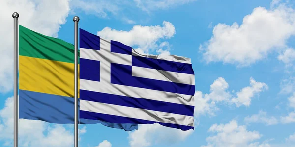 加蓬和希腊国旗在风中飘扬，白云蓝天相拥。外交概念、国际关系. — 图库照片