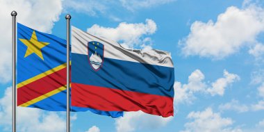 Kongo ve Slovenya bayrağı birlikte beyaz bulutlu mavi gökyüzüne karşı rüzgarda sallayarak. Diplomasi kavramı, uluslararası ilişkiler.