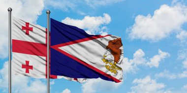 Gürcistan ve Amerikan Samoası bayrağı birlikte beyaz bulutlu mavi gökyüzüne karşı rüzgarda sallayarak. Diplomasi kavramı, uluslararası ilişkiler.