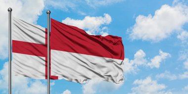 İngiltere ve Monako bayrağı birlikte beyaz bulutlu mavi gökyüzüne karşı rüzgarda sallayarak. Diplomasi kavramı, uluslararası ilişkiler.