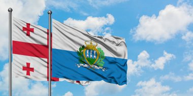 Gürcistan ve San Marino bayrağı birlikte beyaz bulutlu mavi gökyüzüne karşı rüzgarda sallayarak. Diplomasi kavramı, uluslararası ilişkiler.