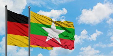 Almanya ve Myanmar bayrağı birlikte beyaz bulutlu mavi gökyüzüne karşı rüzgarsal sallayarak. Diplomasi kavramı, uluslararası ilişkiler.