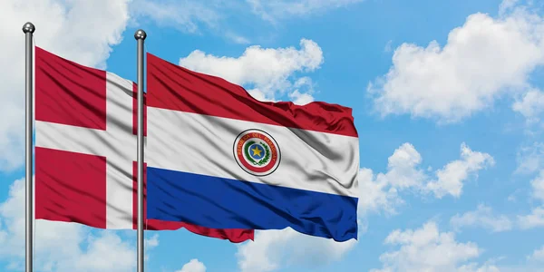 Данія і Парагвай прапор розмахуючи в вітер проти білого хмарного синього неба разом. Концепція дипломатії, міжнародні відносини. — стокове фото
