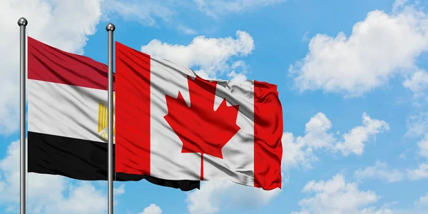 Bandera de Egipto y Canadá ondeando en el viento contra el cielo azul nublado blanco juntos. Concepto diplomático, relaciones internacionales . — Foto de Stock