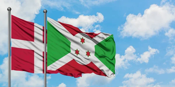 Dania i Burundi flagi machając w wiatr przed białym zachmurzone błękitne niebo razem. Koncepcja dyplomacji, stosunki międzynarodowe. — Zdjęcie stockowe