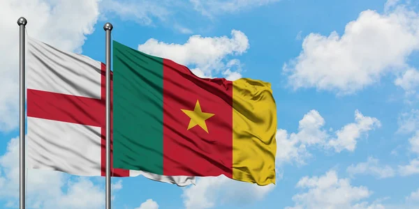 Bandera de Inglaterra y Camerún ondeando en el viento contra el cielo azul nublado blanco juntos. Concepto diplomático, relaciones internacionales . — Foto de Stock