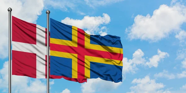 Dánsko a aljašské ostrovy vlají ve větru proti bíle zatažené modré obloze. Diplomacie, mezinárodní vztahy. — Stock fotografie
