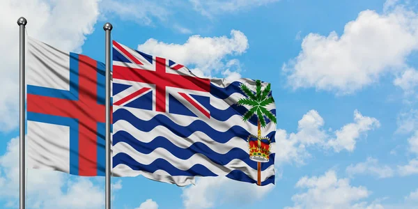 Faroe Islands and British Indian Ocean Territory flag waving in the wind against white cloudy blue sky together. Diplomacy concept, international relations. — Stock Photo, Image