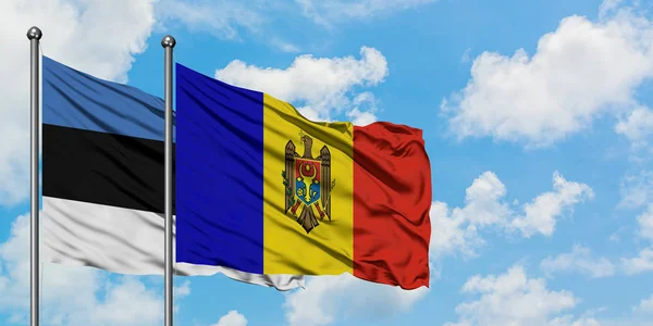 Bandera de Estonia y Moldavia ondeando en el viento contra el cielo azul nublado blanco juntos. Concepto diplomático, relaciones internacionales . — Foto de Stock