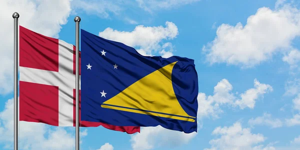 Dania i flaga Tokelau machając w wiatr przed białym pochmurno błękitne niebo razem. Koncepcja dyplomacji, stosunki międzynarodowe. — Zdjęcie stockowe