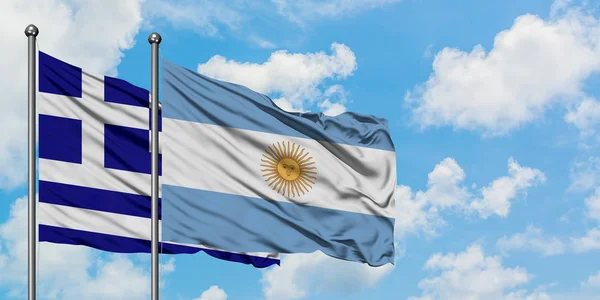 Bandera de Grecia y Argentina ondeando en el viento contra el cielo azul nublado blanco juntos. Concepto diplomático, relaciones internacionales . — Foto de Stock