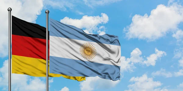 Almanya ve Arjantin bayrağı birlikte beyaz bulutlu mavi gökyüzüne karşı rüzgarsal sallayarak. Diplomasi kavramı, uluslararası ilişkiler. — Stok fotoğraf