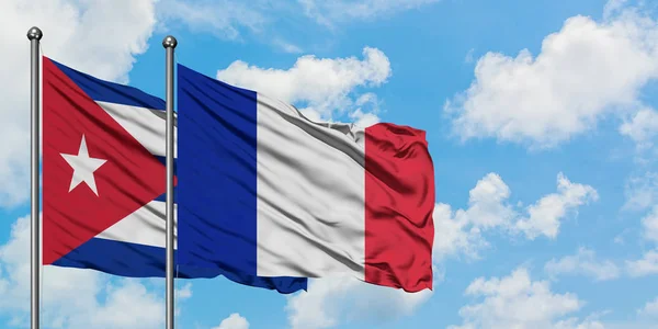 Bandera de Cuba y Francia ondeando en el viento contra el cielo azul nublado blanco juntos. Concepto diplomático, relaciones internacionales . — Foto de Stock