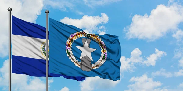 El Salvador and Northern Mariana Islands flag waving in the wind against white cloudy blue sky together. Diplomacy concept, international relations. — Stock Photo, Image