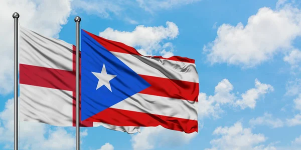 İngiltere ve Porto Riko bayrağı birlikte beyaz bulutlu mavi gökyüzüne karşı rüzgarda sallayarak. Diplomasi kavramı, uluslararası ilişkiler. — Stok fotoğraf