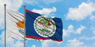 Kıbrıs ve Belize bayrağı birlikte beyaz bulutlu mavi gökyüzüne karşı rüzgarda sallayarak. Diplomasi kavramı, uluslararası ilişkiler.