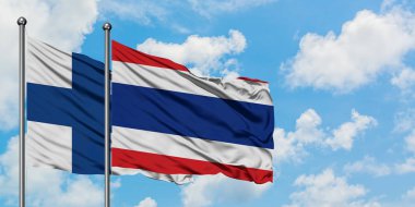 Finlandiya ve Tayland bayrağı birlikte beyaz bulutlu mavi gökyüzüne karşı rüzgarsal sallayarak. Diplomasi kavramı, uluslararası ilişkiler.