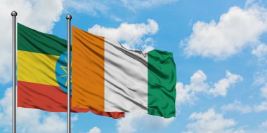 Etiyopya ve Fildişi Sahili bayrağı birlikte beyaz bulutlu mavi gökyüzüne karşı rüzgarda sallayarak. Diplomasi kavramı, uluslararası ilişkiler.