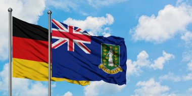 Almanya ve İngiliz Virgin Adaları bayrağı birlikte beyaz bulutlu mavi gökyüzüne karşı rüzgarsal sallayarak. Diplomasi kavramı, uluslararası ilişkiler.