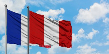 Fransa ve Peru bayrağı birlikte beyaz bulutlu mavi gökyüzüne karşı rüzgarda sallayarak. Diplomasi kavramı, uluslararası ilişkiler.