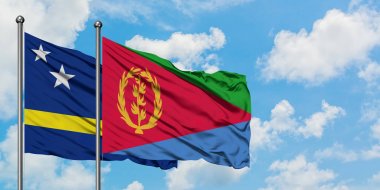 Curacao ve Eritre bayrağı birlikte beyaz bulutlu mavi gökyüzüne karşı rüzgarda sallayarak. Diplomasi kavramı, uluslararası ilişkiler.