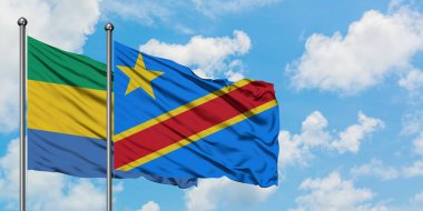 Gabon ve Kongo bayrağı birlikte beyaz bulutlu mavi gökyüzüne karşı rüzgarda sallayarak. Diplomasi kavramı, uluslararası ilişkiler.