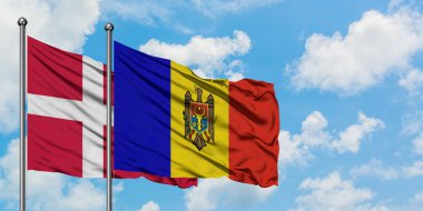 Danimarka ve Moldova bayrağı birlikte beyaz bulutlu mavi gökyüzüne karşı rüzgarda sallayarak. Diplomasi kavramı, uluslararası ilişkiler.