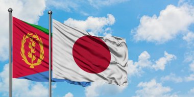 Eritre ve Japonya bayrağı birlikte beyaz bulutlu mavi gökyüzüne karşı rüzgarda sallayarak. Diplomasi kavramı, uluslararası ilişkiler.