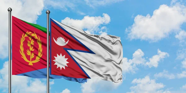 Bandera de Eritrea y Nepal ondeando en el viento contra el cielo azul nublado blanco juntos. Concepto diplomático, relaciones internacionales . — Foto de Stock