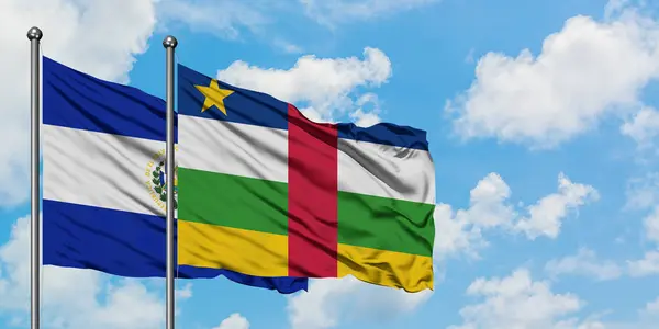 Bandera de El Salvador y República Centroafricana ondeando en el viento contra el cielo azul nublado blanco juntos. Concepto diplomático, relaciones internacionales . — Foto de Stock
