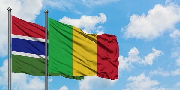 Gambia e bandiera del Mali sventolano insieme nel vento contro il bianco cielo blu nuvoloso. Concetto di diplomazia, relazioni internazionali . — Foto Stock