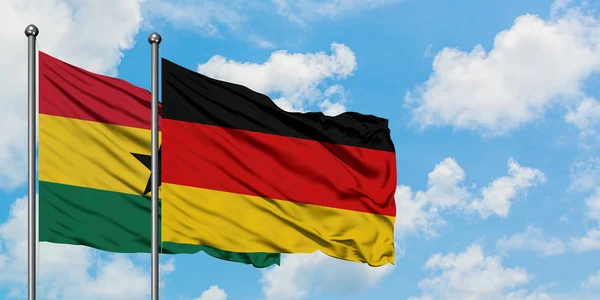 Bandera de Ghana y Alemania ondeando en el viento contra el cielo azul nublado blanco juntos. Concepto diplomático, relaciones internacionales . — Foto de Stock