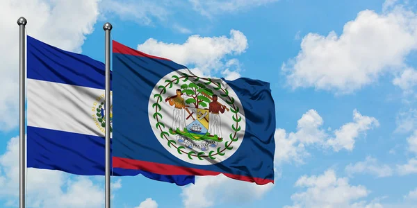 Bandera de El Salvador y Belice ondeando en el viento contra el cielo azul nublado blanco juntos. Concepto diplomático, relaciones internacionales . — Foto de Stock