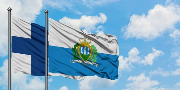 Bandera de Finlandia y San Marino ondeando en el viento contra el cielo azul nublado blanco juntos. Concepto diplomático, relaciones internacionales . —  Fotos de Stock