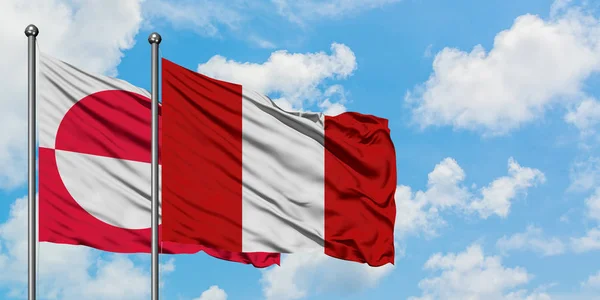 Bandera de Groenlandia y Perú ondeando en el viento contra el cielo azul nublado blanco juntos. Concepto diplomático, relaciones internacionales . — Foto de Stock