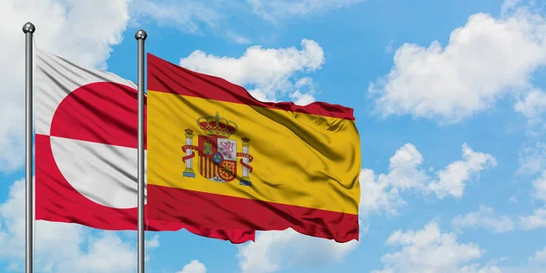 녹색지대와 스페인 국기가 하얀 흐린 푸른 하늘을 배경으로 바람에 흔들리고 있습니다. 외교 개념, 국제 관계. — 스톡 사진