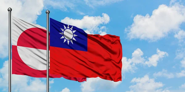 Bandera de Groenlandia y Taiwán ondeando en el viento contra el cielo azul nublado blanco juntos. Concepto diplomático, relaciones internacionales . — Foto de Stock